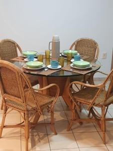 uma mesa de jantar com 4 cadeiras e uma mesa de vidro em Apartamento Caruaru em Caruaru