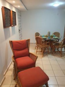 uma sala de estar com uma cadeira e uma mesa com cadeiras em Apartamento Caruaru em Caruaru