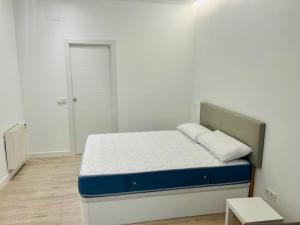 a bedroom with a bed with a blue and white mattress at PISOS NUEVOS MONCLOA ARGUELLES in Madrid