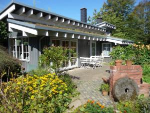 ein Haus mit einer Terrasse und Blumen davor in der Unterkunft Ferienhaus Gartenlust in Dierdorf