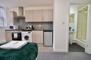 a kitchen with a washer and dryer in a room at Swan Studio Three - Coventry in Coventry