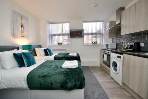 um quarto de hotel com duas camas e uma cozinha em Swan Studio Three - Coventry em Coventry