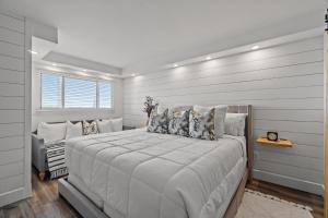 a white bedroom with a large bed with pillows at The Summit 803 - Luxury Beach Resort Condo - Beachfront - Incredible Views - BEACH CHAIRS AND SUNSHADE Provided In Condo in Panama City Beach