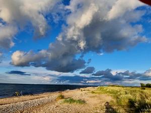 een strand met een bewolkte hemel en de oceaan bij Ferienwohnung an der Ostsee in Lütjenburg