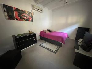 a small bedroom with a bed and a tv at Casa con Piscina y Mirador privado en San Marcos Sierras in San Marcos Sierras +27 photos