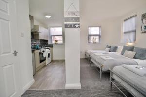 a living room with two beds and a kitchen at Swan Studio Four - Coventry in Coventry