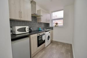 a kitchen with a microwave oven and a sink at Swan Studio Four - Coventry in Coventry