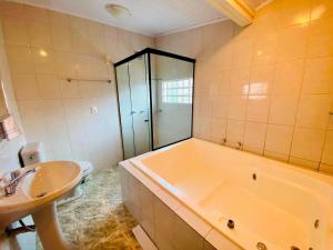 y baño con bañera, lavabo y aseo. en Nena's House - Banheira de Hidromassagem-10 Pessoas, en Gramado