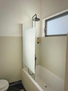 uma casa de banho com um chuveiro, um WC e uma janela. em Baixa24 - Bolhão Apt with Sunset Rooftop no Porto