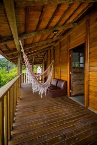 um alpendre com uma rede de descanso numa casa de madeira em Casa do Tesouro em Joinville