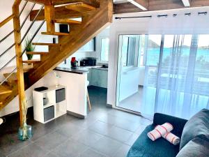 uma sala de estar com um sofá azul e uma cozinha em Le Martini-Vue MER et PINEL terrasse piscine em Cul de Sac