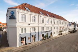 a white building on the side of a street at Best Western Hotel Herman Bang in Frederikshavn
