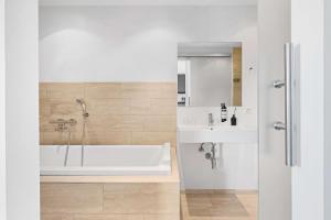 Baño blanco con bañera y lavamanos en Best Western Hotel Herman Bang en Frederikshavn