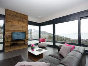 a living room with a couch and a tv at BnB Le Haut des Vignes in Lutry