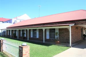 un antiguo edificio de ladrillo con techo rojo en Club Motel Armidale en Armidale