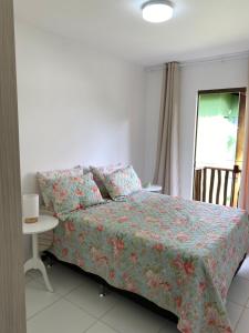1 dormitorio con cama, mesa y ventana en Village Itacimirim, en Camaçari