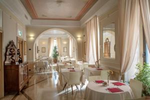 a restaurant with white tables and white chairs at Hotel Canada, BW Premier Collection in Rome