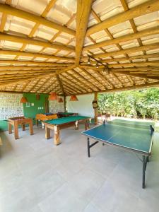 Habitación con 2 mesas de ping pong y techo de madera. en Village Itacimirim, en Camaçari