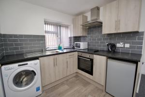 a kitchen with a washing machine and a washer at Gosford Park Studio 5 - Coventry in Coventry