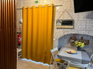 - un rideau jaune dans la salle à manger avec une table dans l'établissement Casinha de São Pedro, à Peniche