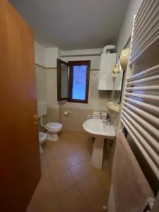 een badkamer met een wastafel, een toilet en een raam bij Villa Natale in Sestola