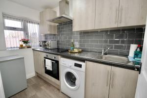 a kitchen with a sink and a washing machine at Swan Studio Six - Coventry in Coventry