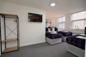 Habitación con 2 camas y TV en la pared. en Swan Studio Six - Coventry, en Coventry