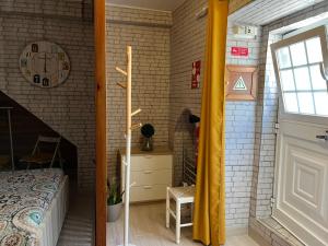 - une chambre avec un lit et un mur en briques dans l'établissement Casinha de São Pedro, à Peniche