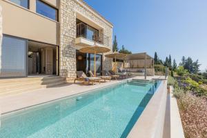 een villa met een zwembad en een huis bij Apeiron Villas in Kefallonia