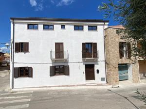 ein weißes Gebäude mit braunen Fensterläden darauf in der Unterkunft casa di natalie in Girasole