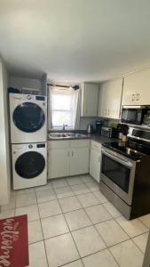 a kitchen with a stove and a sink and a dishwasher at Sunset Paradise Oceanview 1-Bedroom Holiday Home Walking Distance to Beaches & Railway Trail in Hamilton