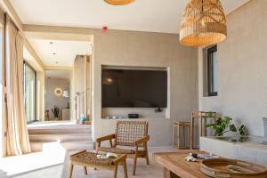 un soggiorno con TV e tavolo di Apeiron Villas a Cefalonia