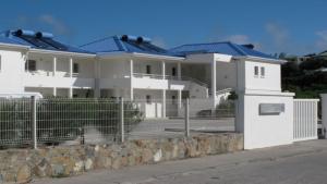 a row of white houses with blue roofs at Le Martini-Vue MER et PINEL terrasse piscine in Cul de Sac