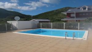 a swimming pool in front of a house at Le Martini-Vue MER et PINEL terrasse piscine in Cul de Sac