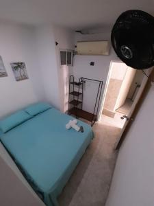 Habitación con cama azul en una habitación en Rivera Hostel, en Santa Marta