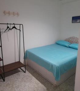 1 dormitorio con 1 cama con sábanas azules y aigil en Rivera Hostel, en Santa Marta