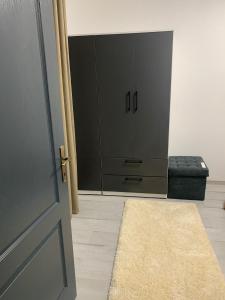 a door to a room with a black cabinet and a rug at Central Apartament in Bîrlad