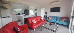 una sala de estar con 2 sofás rojos y azules en Country Comfort - only 10 minutes from Hamilton CBD en Hamilton