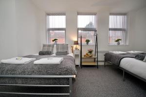 a bedroom with two beds and two windows at Swan Studio Seven - Coventry in Coventry