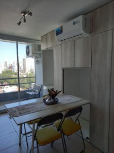 a kitchen with a table and two yellow chairs at 11 De Septiembre 3255 in Mar del Plata +7 photos