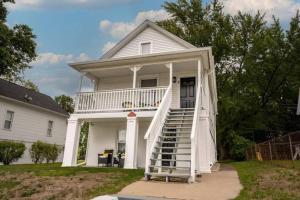 uma casa branca com uma escada que leva até ela em Large-group Retreat w/Loft Space Near Beach em Michigan City