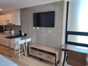 Aparta Suite - Centro Internacional - Mitika في بوغوتا: غرفة معيشة فيها تلفزيون على جدار