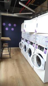 lavadero con 3 lavadoras y una mesa en Aparta Suite - Centro Internacional - Mitika, en Bogotá