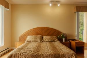 Cama ou camas em um quarto em Auberge de la Rivière Saguenay