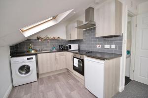 a kitchen with a washer and dryer in it at Swan Studio Nine - Coventry in Coventry