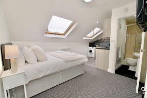 ein Schlafzimmer mit einem Bett und ein Badezimmer mit Oberlichtern in der Unterkunft Swan Studio Nine - Coventry in Coventry