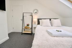 ein weißes Schlafzimmer mit einem großen Bett und einem Spiegel in der Unterkunft Swan Studio Nine - Coventry in Coventry