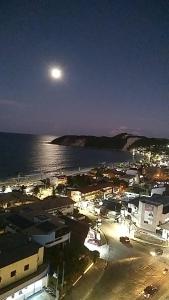 a view of a town with the moon over the water at Apartamentos Natal in Natal