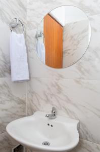 uma casa de banho com um lavatório branco e um espelho. em Markasa Hotel boutique em Cartagena de Indias