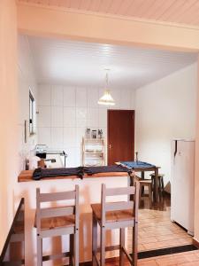 a kitchen with tables and chairs in a room at Lumiar - Casa do Sol in Nova Friburgo